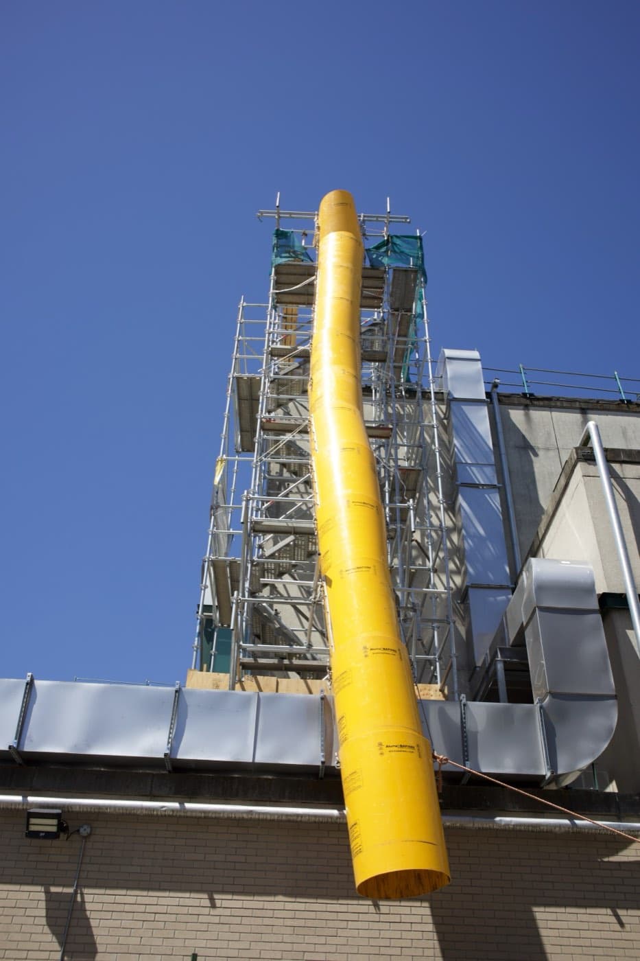 Garbage chute installation on scaffold at Surrey Memorial Hospital
